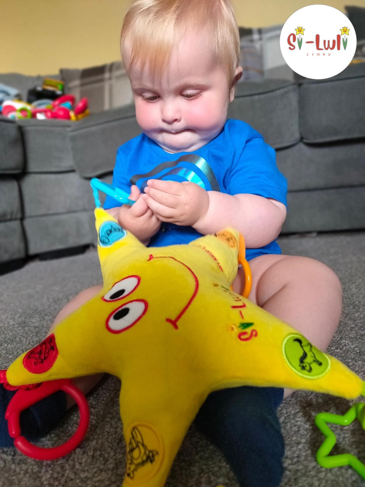 Baby boy playing with Seren Swynol Welsh toy.